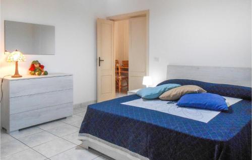 um quarto com uma cama com almofadas azuis e uma cómoda em 3 Bedroom Lovely Apartment In Tortoreto Lido em Tortoreto Lido
