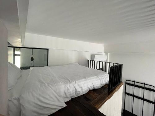 a bedroom with a bed with white sheets and a window at Tomis’ Dreams in Constanţa