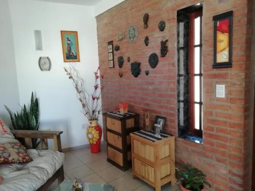 - un salon avec un mur en briques dans l'établissement La casa de Lily, à Alta Gracia