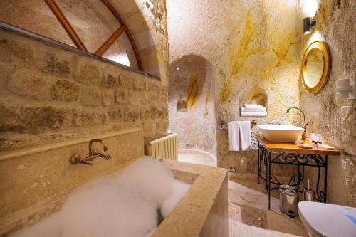 y baño con bañera y lavamanos. en Canyon Cave Hotel, en Ürgüp