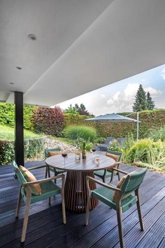 a patio with a table and chairs on a deck at PRIMERA am See in Gaienhofen