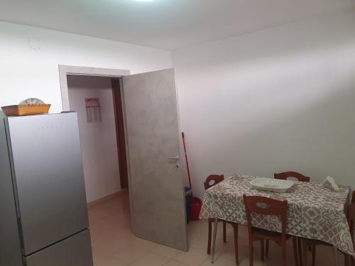 eine kleine Küche mit einem Tisch und einem Kühlschrank in der Unterkunft casa vacanza Nonna Lina in Rosolini