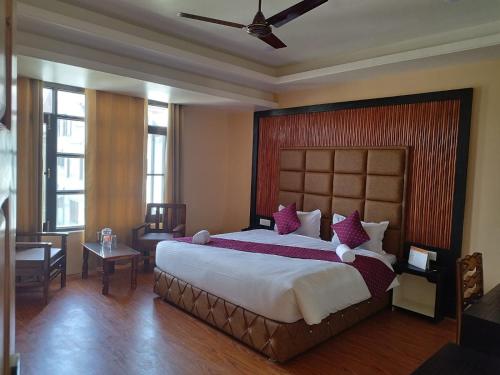 1 dormitorio con 1 cama grande con almohadas moradas en Fair Mount, en Srinagar