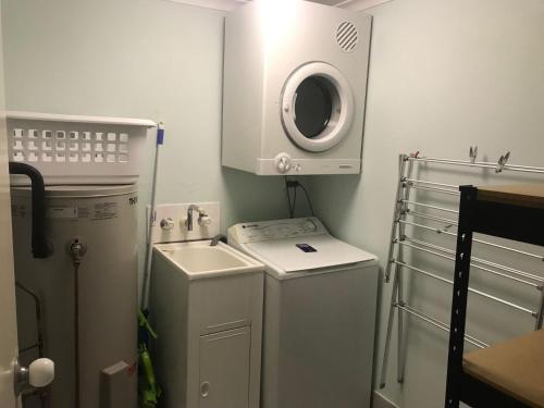 a small bathroom with a sink and a washing machine at Noosa River Gardens 1 Hilton Terrace 76 in Tewantin