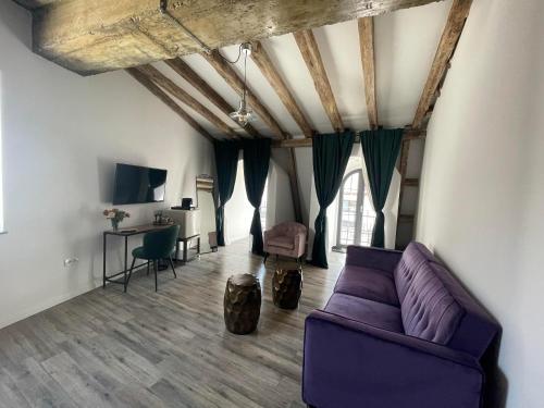 a living room with a purple couch and a table at Tomis’ Dreams in Constanţa
