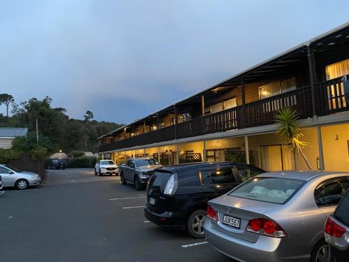 a parking lot with cars parked in front of a building at Commodore Motel in Dunedin