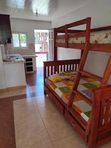 a bedroom with a bunk bed and a kitchen at Capul Beach Resort in Capul