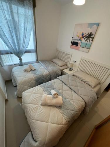 a room with two beds and a window at Sublime appartement vue Mer avec Piscine in El Campello