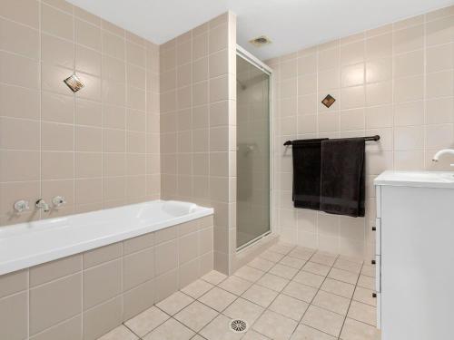 a bathroom with a bath tub and a shower at Beachfront On Marine in Kingscliff