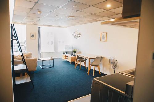a room with a table and chairs and a living room at Liberty Apartment Hotel in Wellington