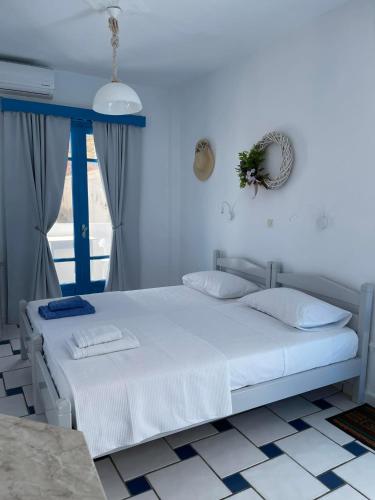 a white bed in a room with a window at GIAVASI SEASIDE FINIKI in Foinikion