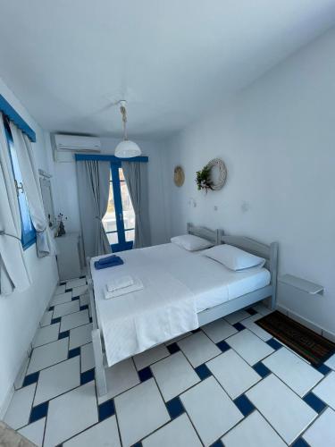 a bedroom with a bed and a tiled floor at GIAVASI SEASIDE FINIKI in Foinikion