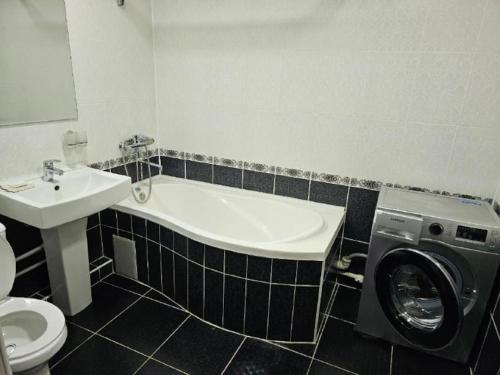 La salle de bains est pourvue d'un lavabo et d'un lave-linge. dans l'établissement Новая 3-х комнатная квартира Мечта, à Boukhara