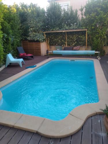 - une piscine sur une terrasse avec une table et des chaises dans l'établissement Anemones, à Castelnau-le-Lez