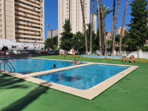 uma piscina numa cidade com pessoas nela em VINTAGE BENIDORM em Benidorm