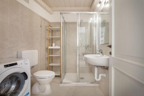 a bathroom with a toilet a sink and a washing machine at Villa Roby-Loft a Torri del Benaco in Torri del Benaco