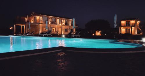 a swimming pool in front of a house at night at Carrua in Marzamemi