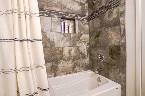 a bathroom with a tub and a shower curtain at Waterfront Retreat, Relaxation, Fun in Hood Canal in Hoodsport