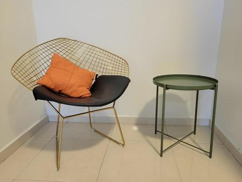 a chair with an orange pillow and a side table at Malacca City Center Town House by 360HOME in Melaka