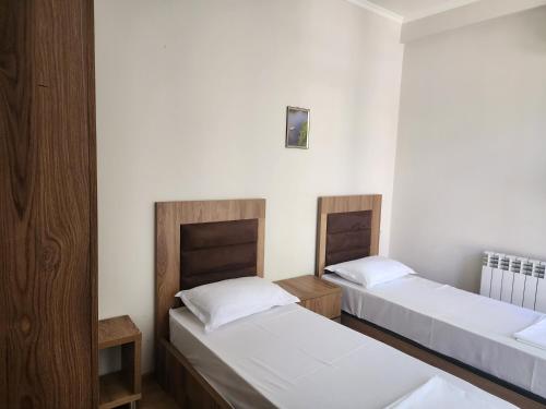 two beds in a room with white walls at Geo Palace Kolkheti National Park in Poti