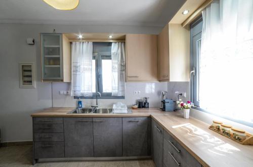 a kitchen with wooden cabinets and a sink and a window at Panoramic View Kea in Péra Meriá