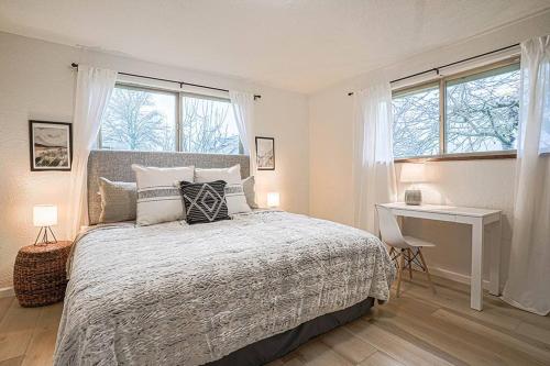 波爾斯波的住宿－Poulsbo Scandinavian Retreat 2 blocks to DT，卧室配有一张床、一张书桌和窗户。