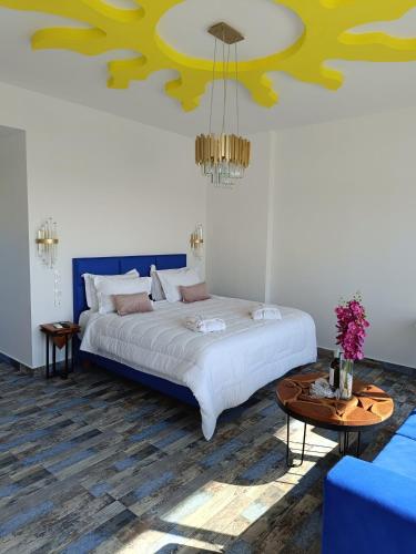 a bedroom with a bed with a blue and yellow ceiling at Haven Beach in Faliraki