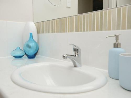 a bathroom with a sink and a blue vase at 16 Chapman Rd - BYO Linen - Pets Negotiable - Wi-Fi in Middleton