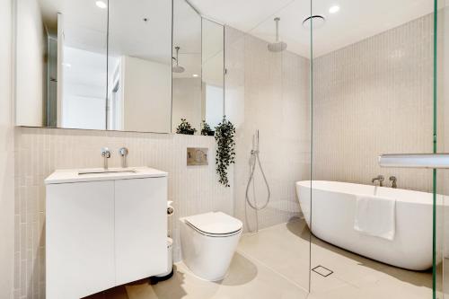 a bathroom with a tub and a toilet and a sink at 3BR 2BATH, Southbank, Crown, Seaview, Level 41 in Melbourne
