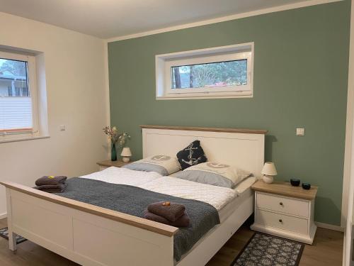 a bedroom with a large bed with two windows at Ferienwohnung TinyBeach in Lubmin