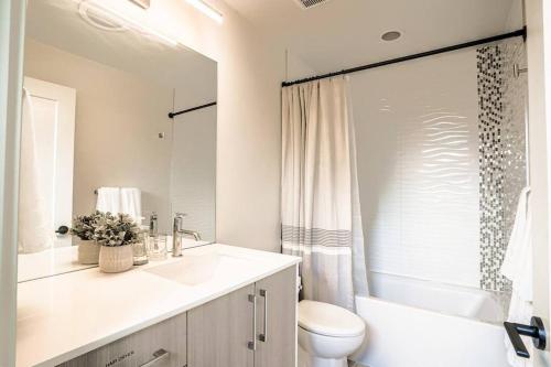 y baño con lavabo, aseo y espejo. en New contemporary home, roof top deck, king bed en Seattle