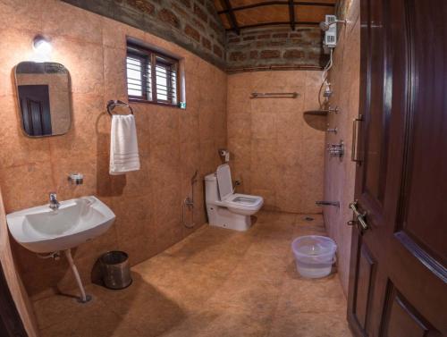 a bathroom with a sink and a toilet at The Copper Edge in Kodlipet