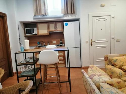 eine kleine Küche mit einem Tisch und einem weißen Kühlschrank in der Unterkunft Acogedora Suite con entrada independiente in El Puerto de Santa María