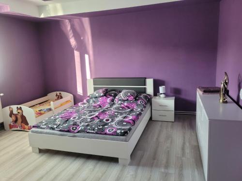 um quarto roxo com uma cama com paredes roxas em Rodinný dom Podhájska em Podhájska