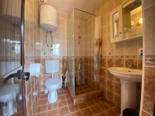 a bathroom with a toilet and a shower and a sink at Guesthouse HHL - Liman ll in Ulcinj