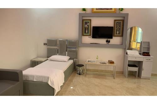 穆桑納的住宿－Super OYO 150 Reef Al Khaleej Resort，一间卧室配有一张床、一张书桌和一面镜子