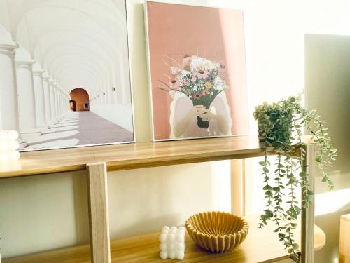 uma prateleira com duas fotos e um vaso de flores em Central Apartment St Leonards em Sidney