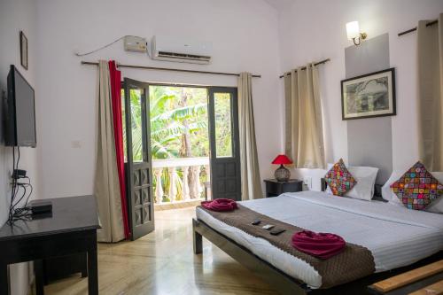 una camera con letto e porta scorrevole in vetro di RONNE'S VILLA De SOL-3BHK LUXURY VILLA In Assagaon a Mapusa