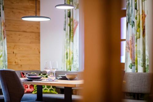 a dining room with a wooden table and chairs at Thorbäck Gut - Apartments im Schlosserhaus in Öblarn