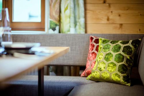 a pillow sitting on a couch next to a table at Thorbäck Gut - Apartments im Schlosserhaus in Öblarn
