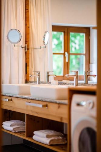 a bathroom with a sink and a large mirror at Thorbäck Gut - Apartments im Schlosserhaus in Öblarn