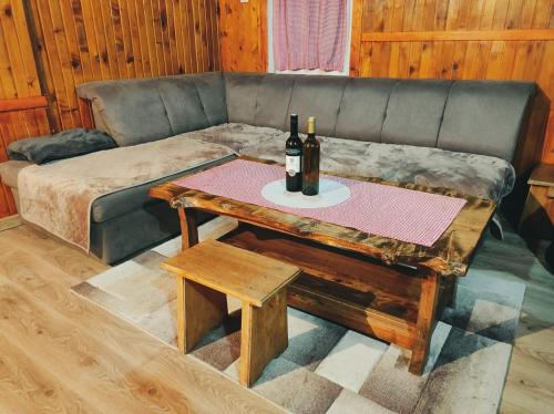 a couch with a table with wine bottles on it at Holiday Home Ljuban in Risovac