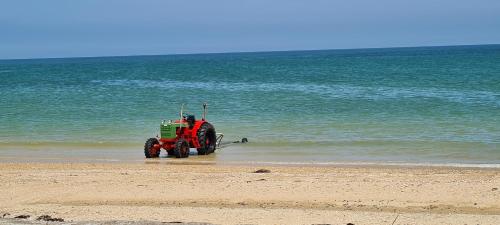 a tractor is stuck in the sand on the beach at Relais des îles Saint Marcouf in Saint-Marcouf