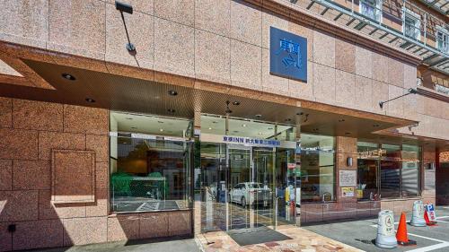 a store front of a brick building with glass windows at Toyoko Inn Shin-osaka Higashi-mikuni Ekimae in Osaka