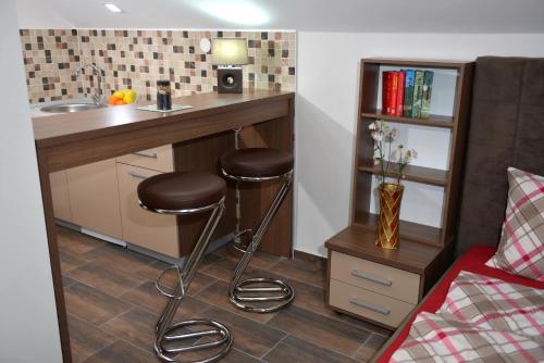 a kitchen with a sink and stools in a room at Velestovo House in Ohrid