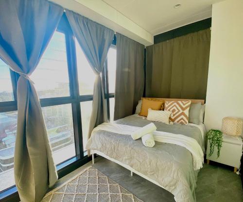 een slaapkamer met een bed en een groot raam bij Central Apartment St Leonards in Sydney