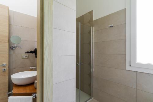 a bathroom with a glass shower and a sink at Le scuderie 6 in Galatone