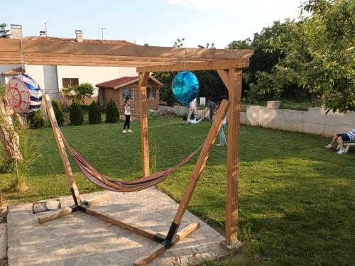 a hammock with a wooden structure in a yard at Вила Полина in Varna City