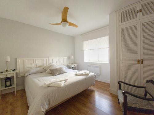 a bedroom with a bed with a ceiling fan at La Casita de Rosa - Sierra de Francia in Aldeanueva de la Sierra