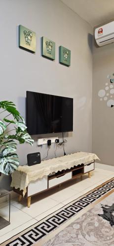 ein Wohnzimmer mit einem TV und einem Couchtisch in der Unterkunft ER Homestay for Family Transit Nearby KLIA in Sepang